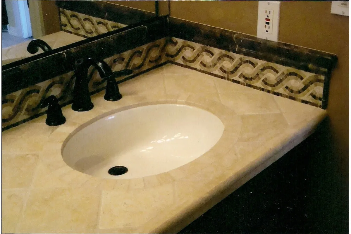 Master bathroom with a decorative stone tile border and travertine vanity top.